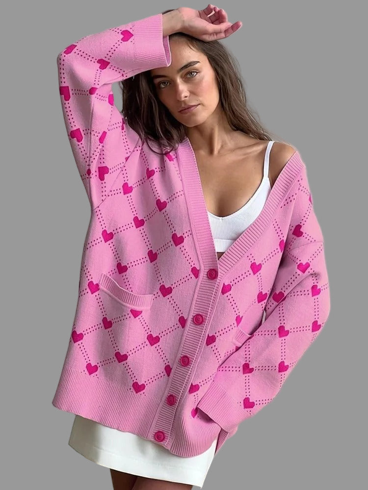 Die Oversized-Strickjacke Heartyy Heart Pinkyy Cardigan von CozyWoolCraft kombiniert Komfort und Stil – kuscheliger Look mit süßem Herzmuster in Rosa und Pink.