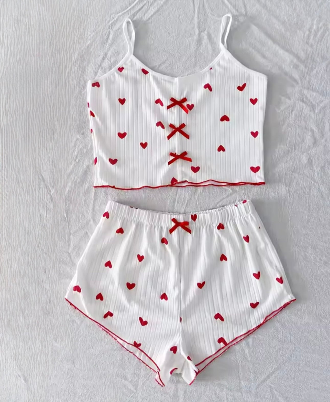 Weißes Pyjama Set mit roten Herzen und Schleifendetail, weiches Cami-Top mit Shorts aus geripptem Stoff, cozy und feminin.