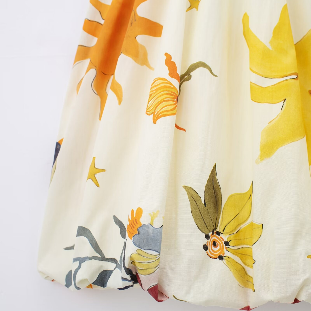 Detailaufnahme des Ellyy Kuschel Oberteils zeigt das leuchtende Blumenmuster in Gelb, Orange und Rosa – feminin, verspielt und hochwertig.
