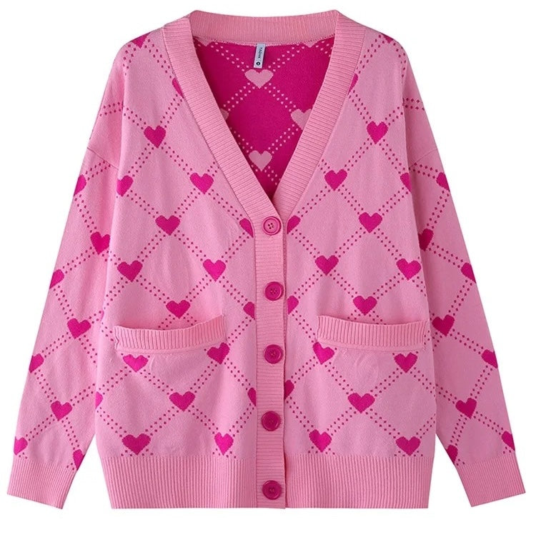 Der Heartyy Heart Pinkyy Cardigan von CozyWoolCraft ist eine rosa Strickjacke mit pinkem Herzmuster, Knöpfen und Taschen – feminin, cozy und stylisch zugleich.