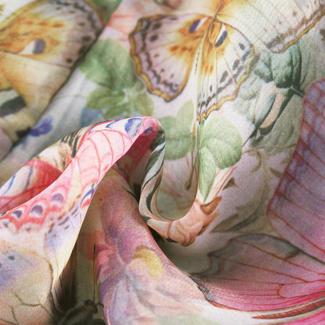 Detailaufnahme des Stoffes des Karyy Floralen Minikleids – weicher Chiffon mit floralen und Schmetterlings-Prints in zarten Pastelltönen.