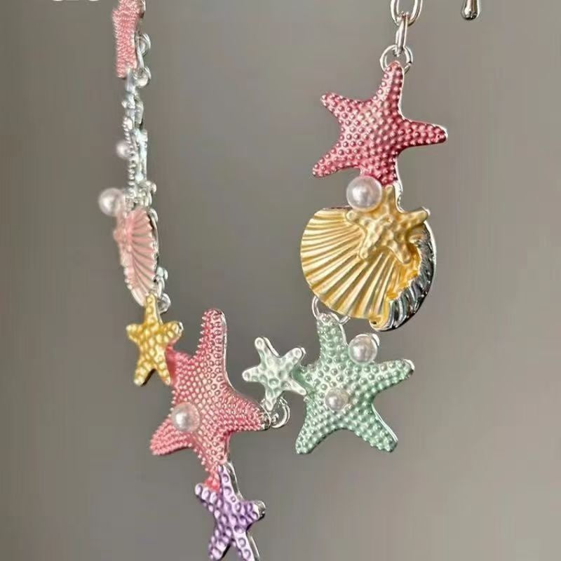 Maddyy Maritime Halskette mit detailreichen Seestern- und Muschel-Anhängern in Rosa, Gelb, Grün und Lila – zarter Statement-Schmuck von CozyWoolCraft.