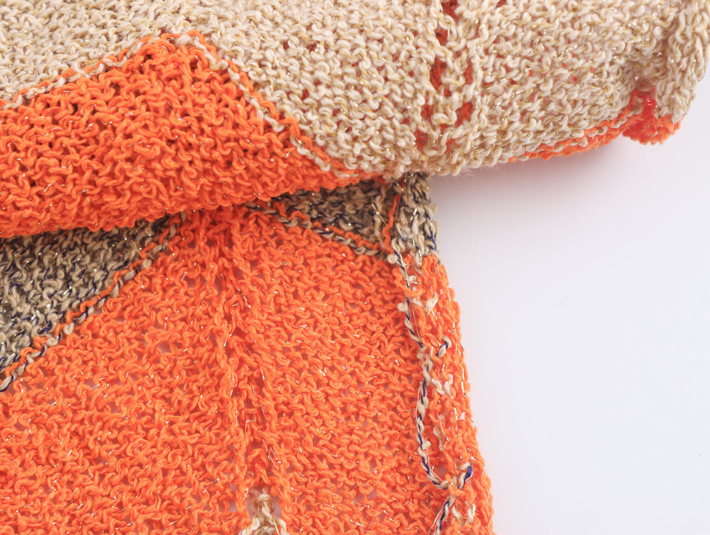 Detailaufnahme vom Samyy Strickkleid Halterneck – feine Strickstruktur mit Zickzackmuster in Orange, Beige und Grau für modernen Retro-Chic.