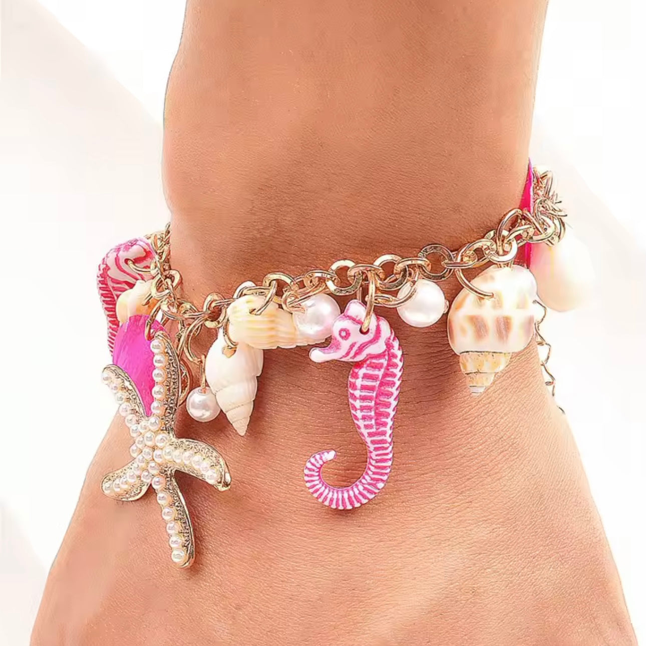 Goldenes Armband mit rosa Seepferdchen, Seestern und Muschel-Details – auffälliger Beach Schmuck für Damen von CozyWoolCraft.
