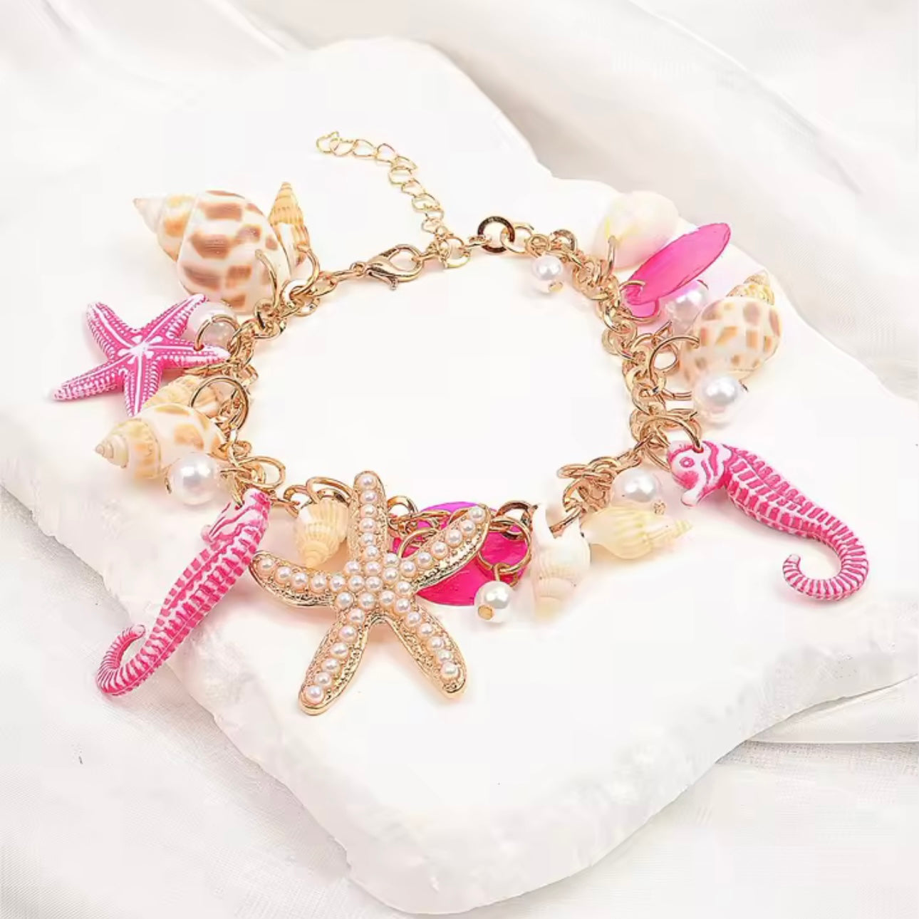 Boho Armband mit Seestern und echten Muscheln in Pink-Gold, dekoriert mit Perlen – maritimer Schmuck von CozyWoolCraft.