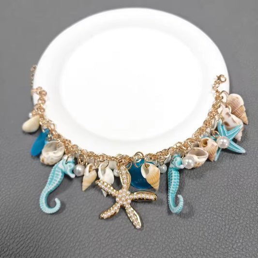 Tyfyy Seestern Muschel Armband in Blau – eleganter maritimer Schmuck mit Seepferdchen, Muscheln und goldener Kette.